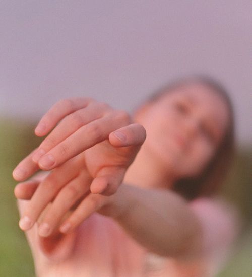 Person stretching outdoors at sunrise, feeling energized and vibrant.